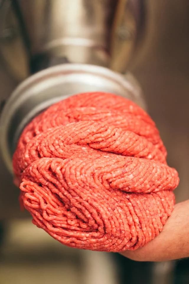Fresh beef being ground through the grinder at Jaworski Meats, made in-house daily with no fillers