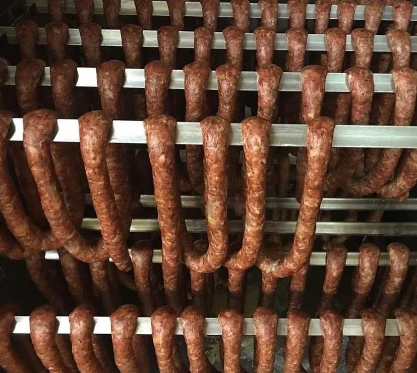 Polish kielbasa smoking on racks at Jaworski Meats — overhead view of the smoker